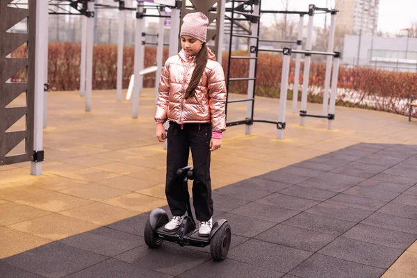 Personal eco transport, gyro scooter, smart balance wheel. A little girl riding a electric self-balancing scooter. child is balancing on a gyroscooter.