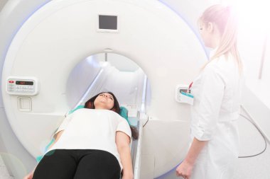 Modern hastane laboratuvarında bir hastaya tıbbi tomografi ya da MRI taraması yapın. Radyografi bölümünün içi. Beyaz odada teknolojik olarak gelişmiş ekipmanlar var. Manyetik rezonans tanılama makinesi.