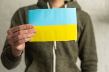 Ukrainian flag in hands. The concept of ending the war in Ukraine
