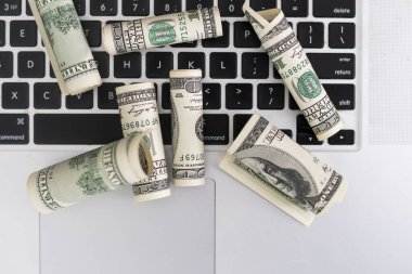 Çevrimiçi ya da çevrimiçi gelir kavramı. Dizüstü bilgisayarda 1 dolarlık banknotlar.