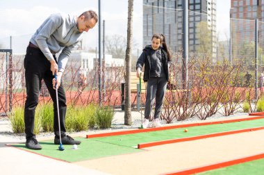 Yapay çimlerin üzerinde mini golf topu. Yaz sezonu oyunu.