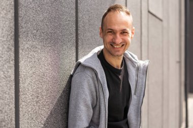 Gri arka planda izole bir şekilde kollarını kavuşturmuş, orta yaşlı, başarılı bir beyaz adam..