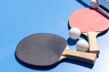 ping pong raketleri ve toplar mavi arka planda, yer, spor ve hobi tasarrufu