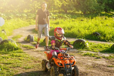 Baba ve kızı yolda gün anda oynamak. Onlar parkta quad bisiklet sürüş. İnsanlar doğa üzerinde eğleniyor. Dostu aile kavramı.