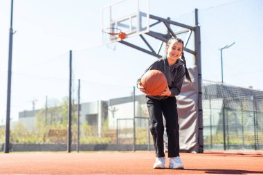 Güzel kız basket atıyor ve basketbol oynuyor..