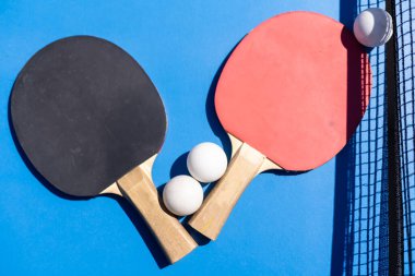 ping pong raketleri ve toplar mavi arka planda, yer, spor ve hobi tasarrufu