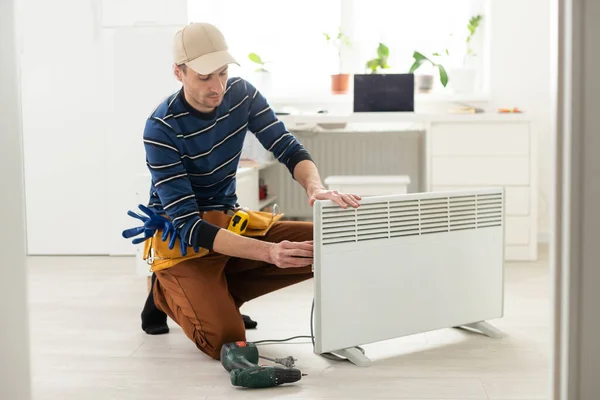 Master Repairs Electric Heater — Stock Photo, Image