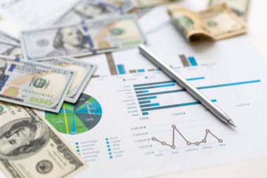 İşletme grafiği kağıt kalem hesap makinesi ofis masasında bir dolar. Mali raporlar kontrol ediliyor