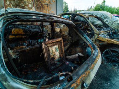 Yangından sonra iki araba. Kaputu açık, yanmış iki araba. Kundaklama, yanmış araba.