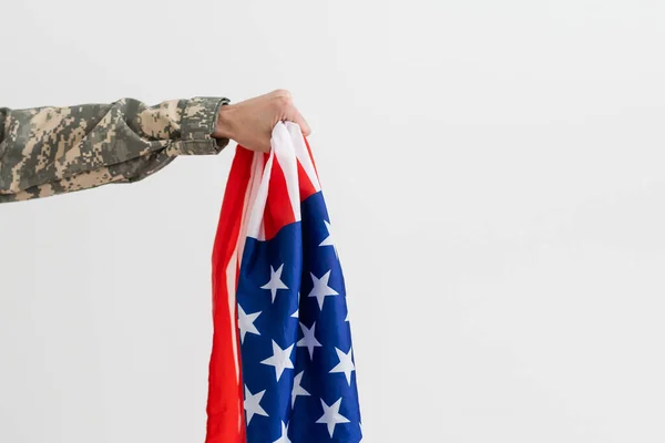 american military soldier holding flag. male officer in camouflage uniform. Concept of military, army