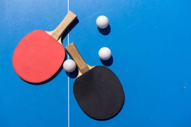 ping pong raketleri ve toplar mavi arka planda, yer, spor ve hobi tasarrufu