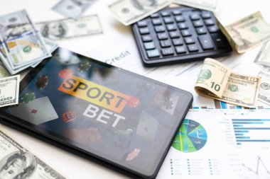 Dijital tablet üzerinde borsa veri uygulaması olan modern iş yeri, akıllı telefon üzerinde mobil bankacılık arayüzü ve masaüstünde grafikler, grafikler ve numaralar olan bazı kağıtlar.