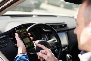 Adam arabada cep telefonu kullanıyor, spor bahisleri oynuyor..