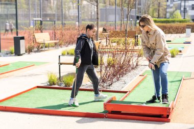 Anne mini golfte sevimli kızıyla oynuyor..