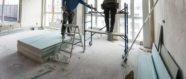 工人们用干墙组装悬吊的天花板 高质量的照片 — 图库照片