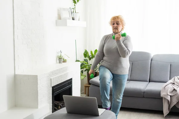 stock image Home Sport. Active Senior Woman Doing Warming Stretching Exercises In Front Of Laptop, Training With Online Tutorials.