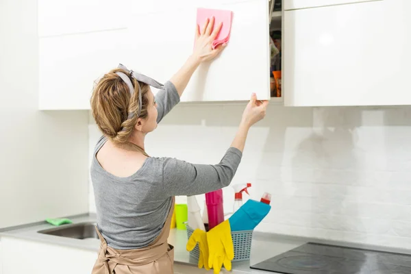 迷人的女人在厨房用抹布擦家具 — 图库照片