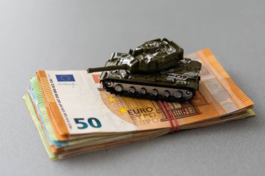 Avro banknotlarının arka planında oyuncak askeri tank.