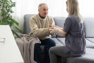 doktor ofisinde kıdemli erkek hastasını konuşuyor
