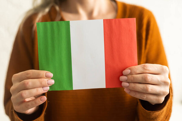 Person holding a Italian flag on a white background.