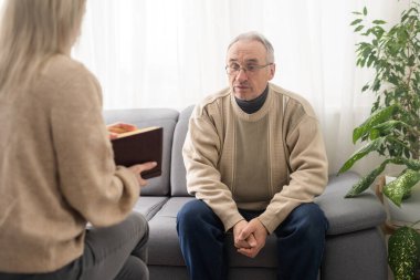 Psychology, depression people. Elderly adult man, men consulting with psychologist, psychiatrist while elderly, old patient counseling mental with doctor woman at clinic. Encouraging, therapy.