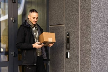 Binanın girişinde kameralı bir adam var.