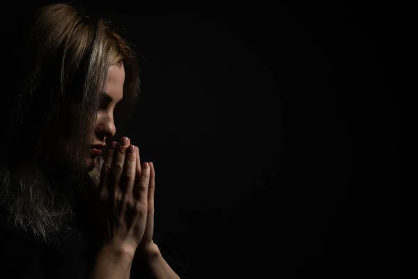 女性の手の黒い背景に一緒に祈って — ストック写真