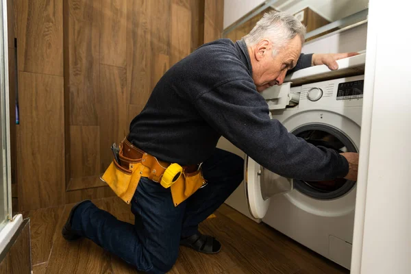Homem Idoso Repara Uma Máquina Lavar Roupa — Fotografia de Stock