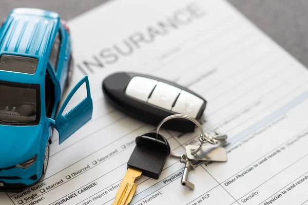 stock image Top view of car insurance claim form with car key and car toy on desk.