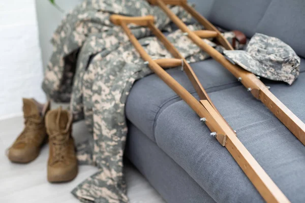 military uniform with crutches. disability.