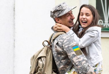Ukrayna askeri üniformalı babası ve kızı. Aile toplantısı.
