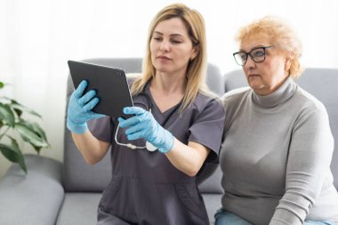 Bir tablet tutarak ve onu hasta için konuşmak genç bir doktor doz.