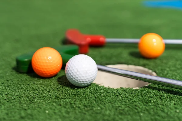 バットとボールでミニチュア ゴルフ穴のクローズ アップ — ストック写真