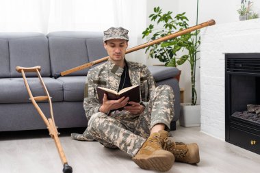 Koltuk değnekli askeri üniformalı asker..