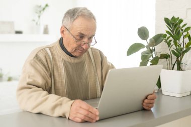 Laptop kullanan akıllı, olgun, profesyonel bir adam. Orta yaşlı yetişkin iş adamı, orta yaşlı uzaktan kumandalı girişimci ya da online daktilo yazmayı öğreniyor