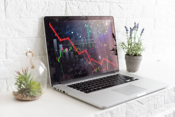Global economic recession, stock market crash and inflation concept with digital falling down red candlestick and diagram on modern laptop keyboard background.