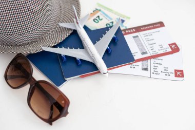 Işık panolarında seyahat aksesuarları. Şapka, kamera, pasaport ve gözlüklü belge sahibi..