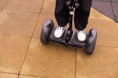 Kişisel çevre taşımacılığı, jiroskoplu scooter, akıllı denge çarkı. Elektrikli, dengeli scooter kullanan küçük bir kız. Çocuk bir jiroskopta dengede duruyor.