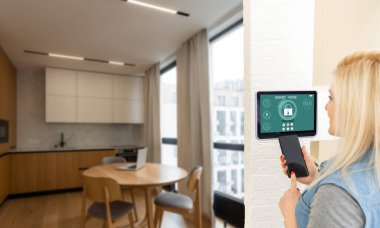 Oturma odasındaki duvara dijital dokunmatik ekran panelle evi kontrol etmek. Evdeki akıllı aygıtları yönetmek için akıllı ev ve mobil uygulama kavramı