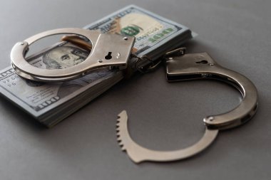 Kelepçeler yüz dolarlık banknotların üzerinde. Güç ve rüşvet. Suçlu fidyesi. Suçlu kazancı. İş konsepti. Zenginlik kavramı.