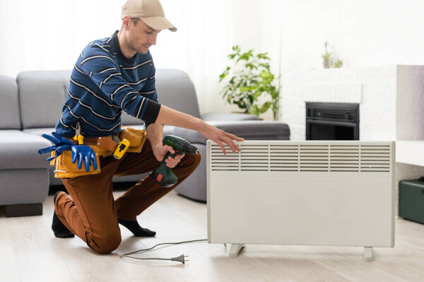 Modern electric heater on floor at home. the master repairs the electric heater