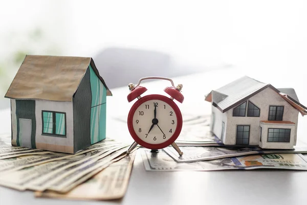 Estate tax, Alarm clock with model house. Business investment and Property tax concept.