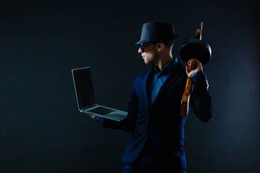 businessman in sunglasses with machine gun and laptop.