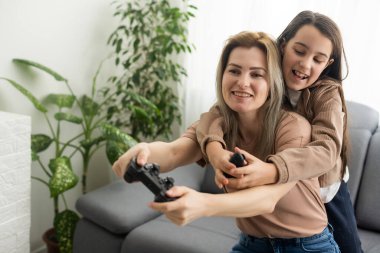 iyi bir ilişki içinde küçük tatlı bir kız ve genç bir anne oyun oynuyor birlikte oturma odasında tahta zeminde oturmuş aile tatilinin tadını çıkarıyorlar..