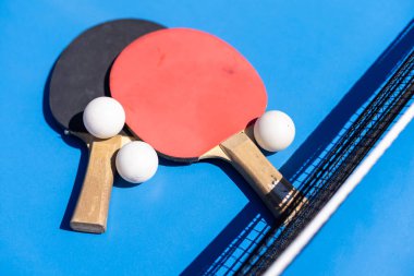 Spor kompozisyonu. Ping pong yakın plan. Mavi arkaplanda oynamak için raketler