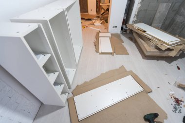 Mobilya yerleştirme ve montaj konsepti. İçinde mobilya olan bir karton kutuyu açıyorum. Dairenin sahibine ait yeni mobilyalar montajı