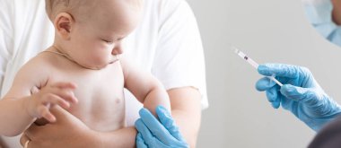 Doktor beyaz arka planda bebek aşısı yapıyor.
