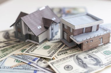 Amerikan doları banknotlarının arka planındaki kağıt ev modeli. Konut piyasası, emlak satın alma veya kiralama.