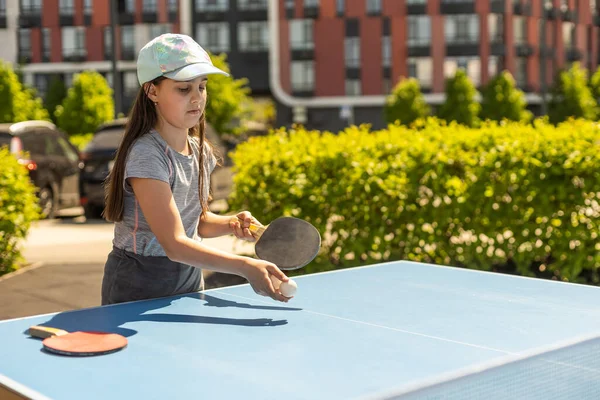 stock image Little charming happy girl child plays ping pong.