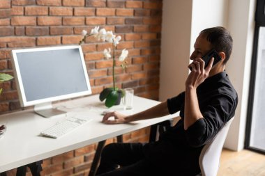 Young business man working at home with laptop on desk.